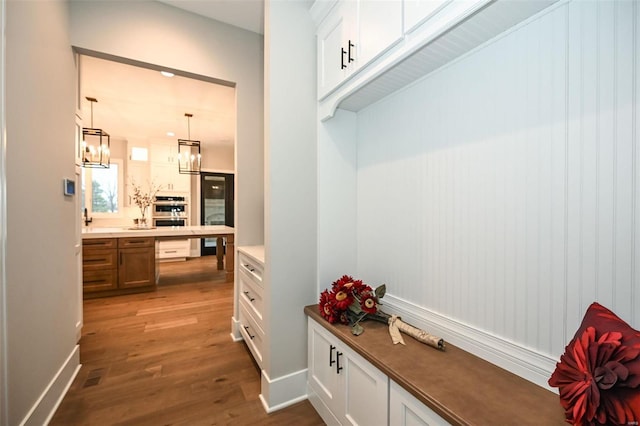 mudroom with a notable chandelier and dark hardwood / wood-style flooring