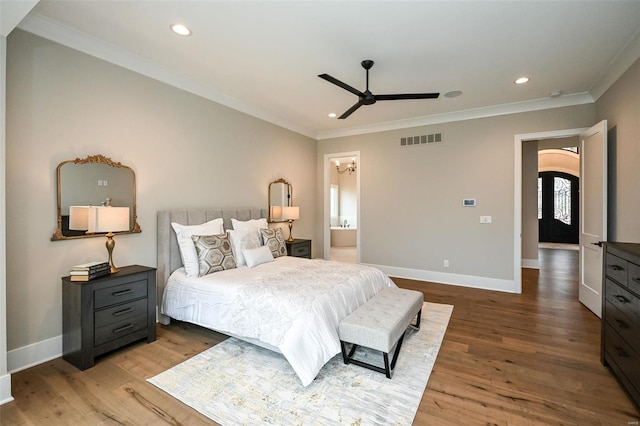 bedroom featuring hardwood / wood-style floors, ensuite bath, ceiling fan, and ornamental molding