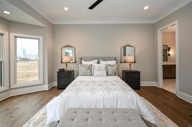 bedroom with dark wood-type flooring, ceiling fan, crown molding, and connected bathroom