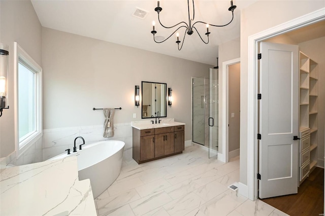 bathroom with a chandelier, separate shower and tub, a healthy amount of sunlight, and vanity