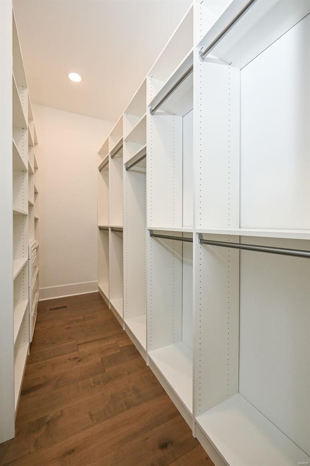 walk in closet with dark hardwood / wood-style floors