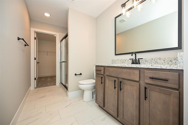 bathroom with toilet, an enclosed shower, and vanity