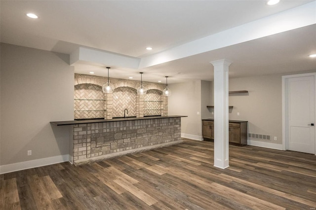 bar with sink, dark wood-type flooring, and decorative light fixtures