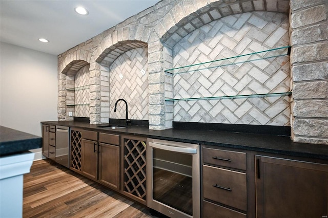 bar with wine cooler, dark hardwood / wood-style floors, sink, dark brown cabinets, and stainless steel dishwasher