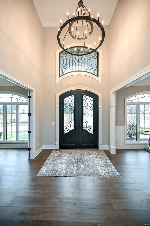 foyer entrance with a chandelier, french doors, dark wood-style floors, and baseboards