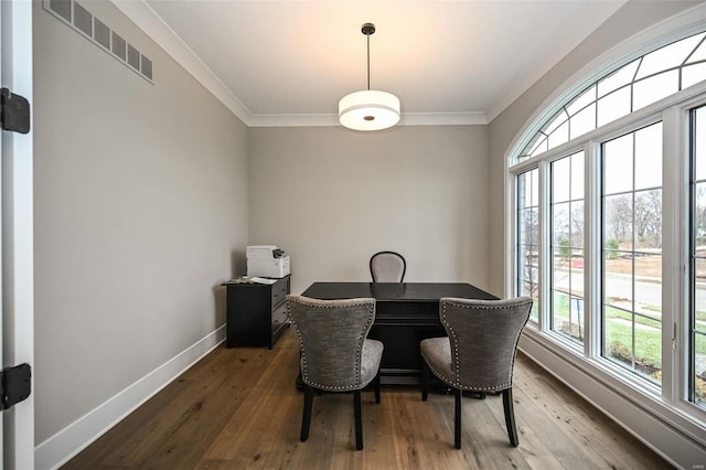 dining area with wood-type flooring, visible vents, crown molding, and baseboards