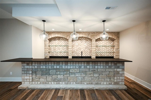 bar with decorative light fixtures, dark wood finished floors, and baseboards