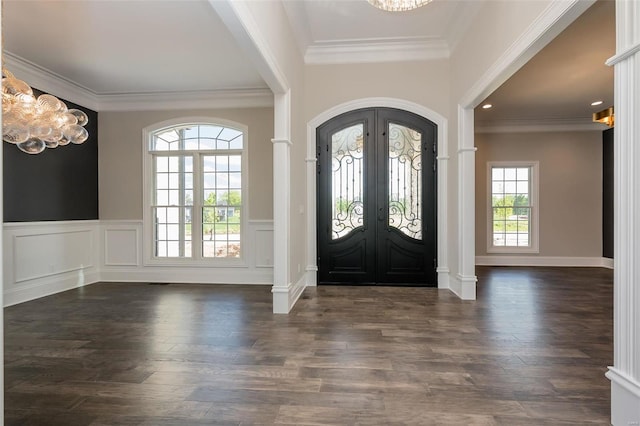 entryway featuring a wainscoted wall, ornamental molding, wood finished floors, french doors, and an inviting chandelier