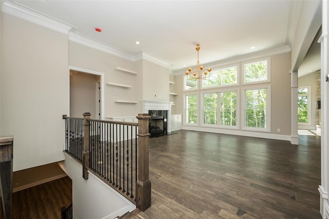 living room featuring an inviting chandelier, crown molding, dark wood-style floors, and a premium fireplace