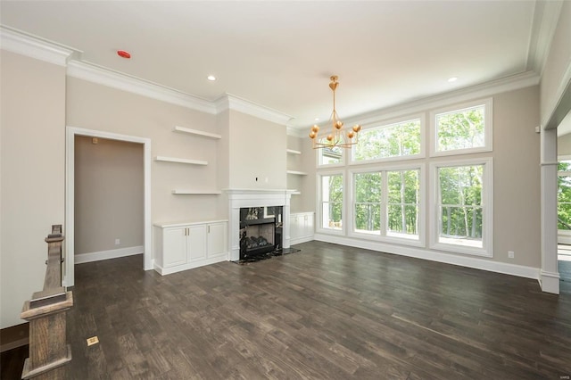 unfurnished living room featuring built in shelves, ornamental molding, dark wood-style floors, a premium fireplace, and baseboards