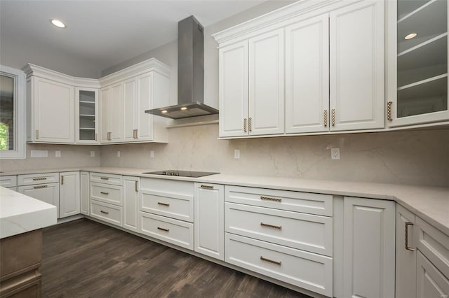 kitchen featuring dark wood-style floors, white cabinets, glass insert cabinets, wall chimney exhaust hood, and black electric cooktop