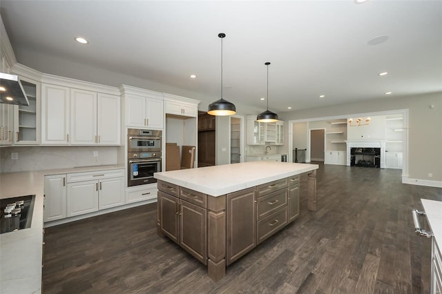 kitchen with white cabinetry, double oven, glass insert cabinets, and dark wood-type flooring