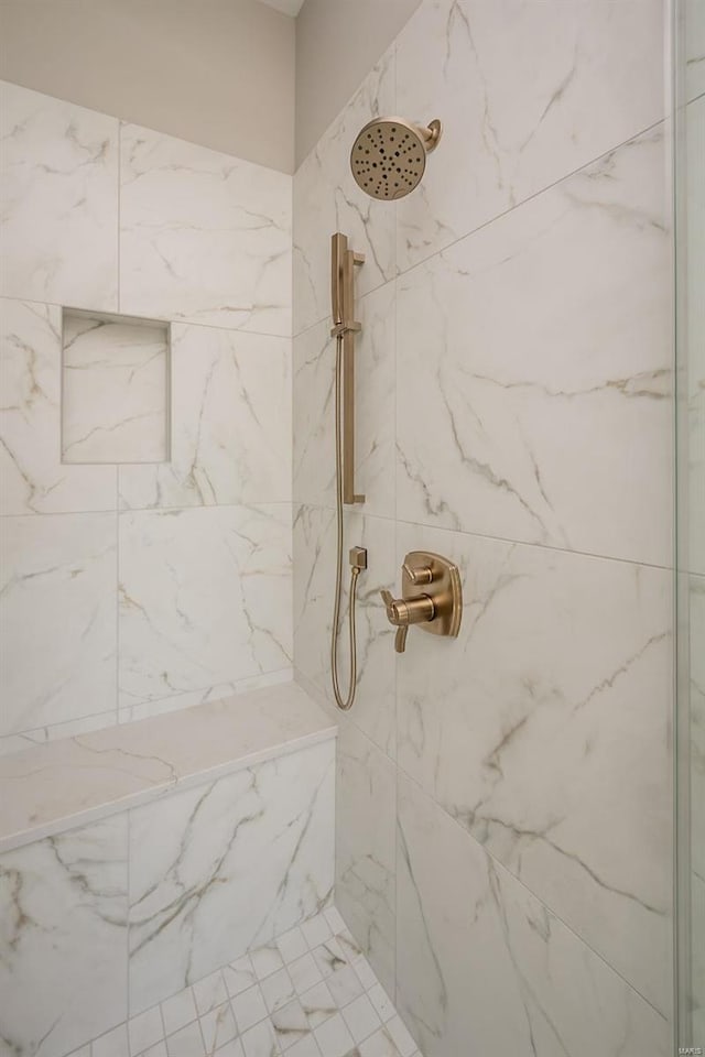 bathroom featuring a marble finish shower