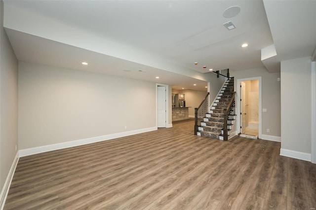 basement with stairway, recessed lighting, wood finished floors, and baseboards