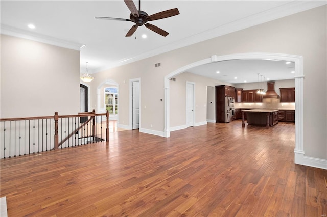 empty room featuring ceiling fan, crown molding, and hardwood / wood-style floors