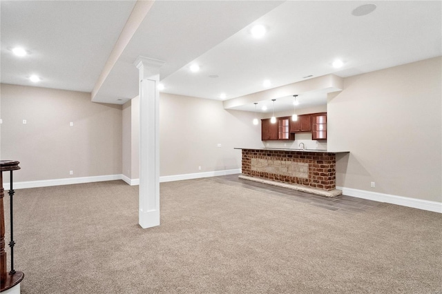 unfurnished living room with ornate columns and carpet