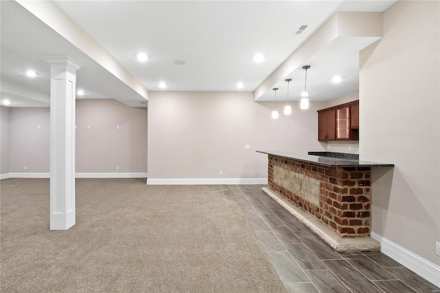 unfurnished living room with dark colored carpet and decorative columns