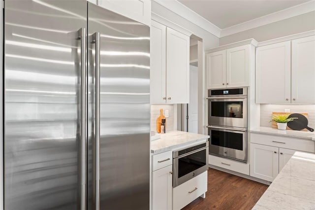 kitchen with white cabinetry, light stone countertops, and stainless steel appliances