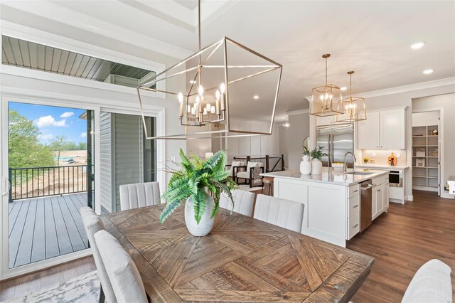 dining area with an inviting chandelier, ornamental molding, dark hardwood / wood-style flooring, and sink