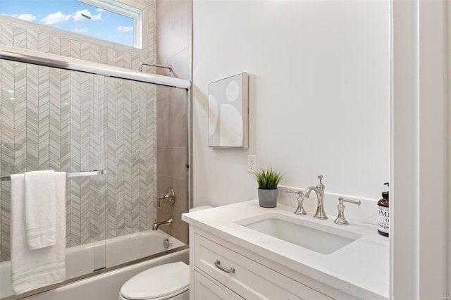 full bathroom with vanity, combined bath / shower with glass door, and toilet