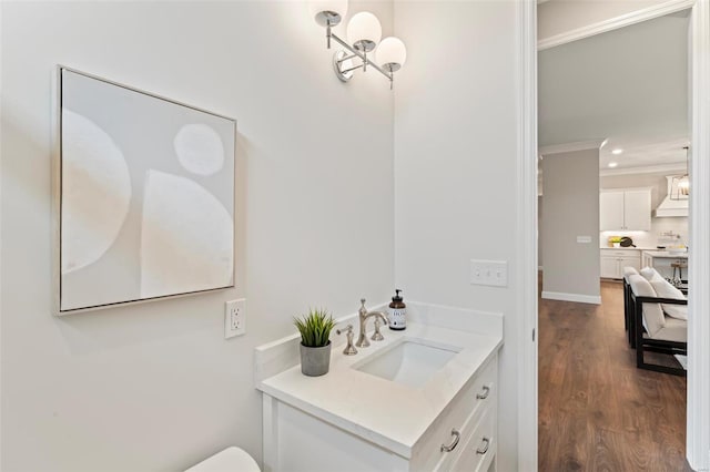 bathroom featuring hardwood / wood-style flooring, crown molding, and vanity