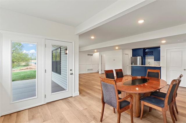 dining area featuring indoor wet bar and light hardwood / wood-style flooring