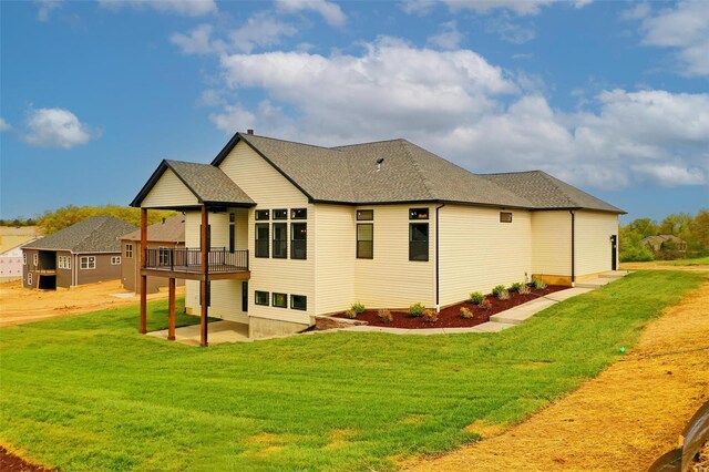 rear view of property with a lawn and a patio