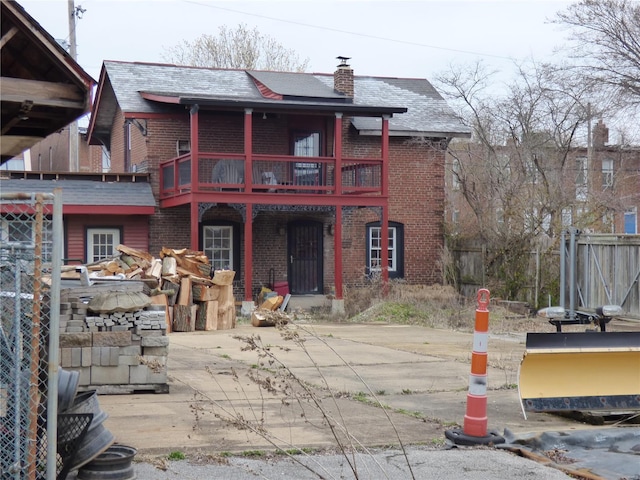 view of front of home with a balcony and a patio