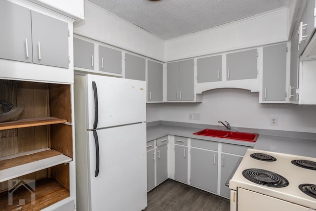 kitchen featuring range, dark wood-type flooring, white fridge, sink, and a textured ceiling