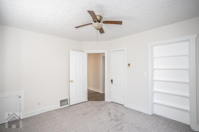 unfurnished bedroom featuring light carpet, a closet, ceiling fan, and a textured ceiling