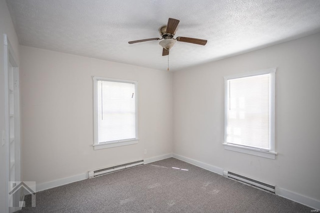 unfurnished room featuring a wealth of natural light, ceiling fan, and a baseboard heating unit