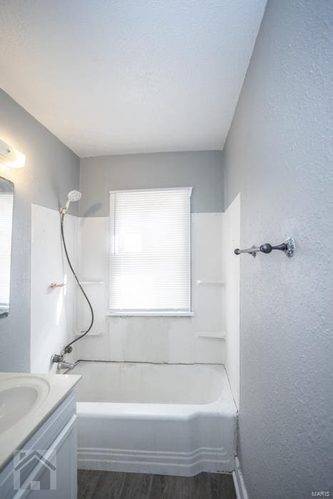 bathroom featuring vanity,  shower combination, and hardwood / wood-style flooring