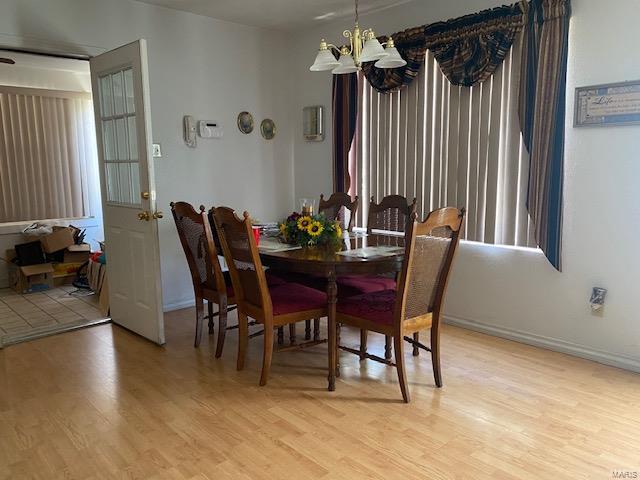 dining area featuring an inviting chandelier and light hardwood / wood-style flooring