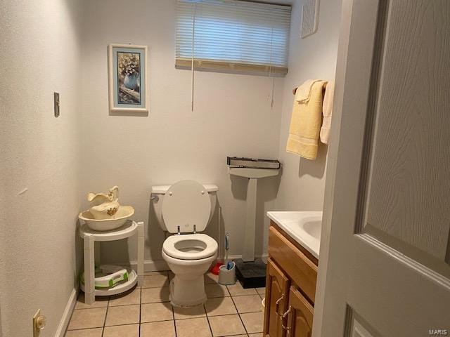 bathroom featuring toilet, vanity, and tile flooring