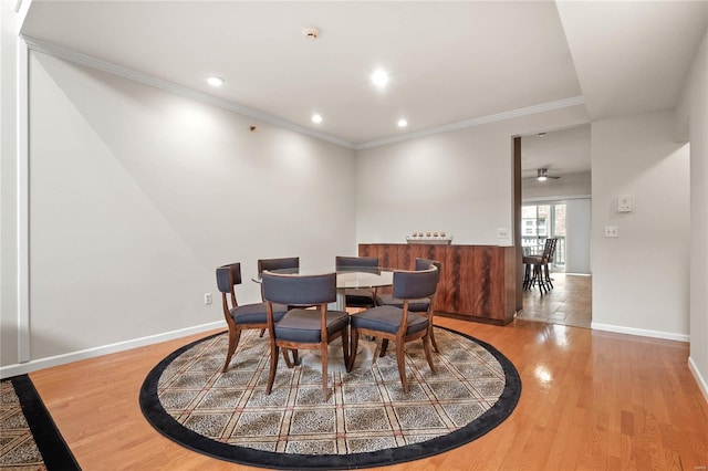 dining room featuring crown molding, wood-type flooring, and ceiling fan