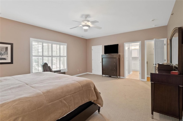 carpeted bedroom with ensuite bathroom and ceiling fan