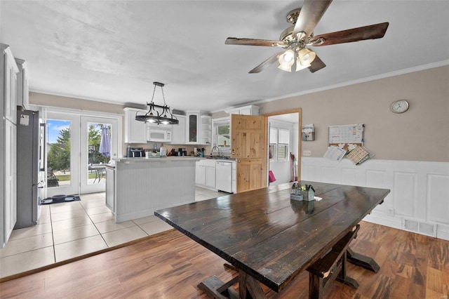 dining area with crown molding, sink, light wood-type flooring, and ceiling fan