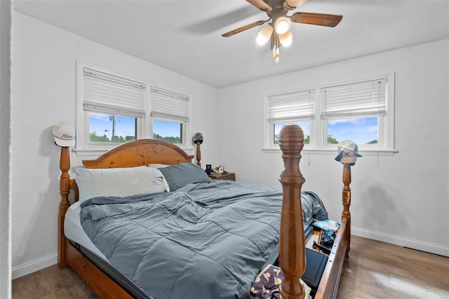 bedroom with hardwood / wood-style flooring, multiple windows, and ceiling fan