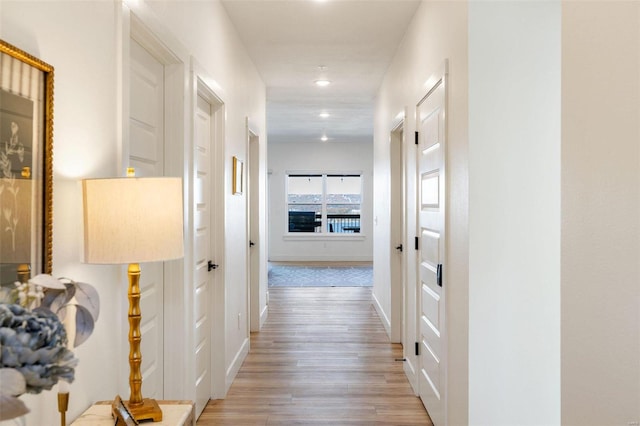 hallway featuring light wood-type flooring, baseboards, and recessed lighting