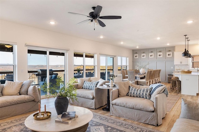 living area featuring a ceiling fan, light wood-style flooring, and recessed lighting