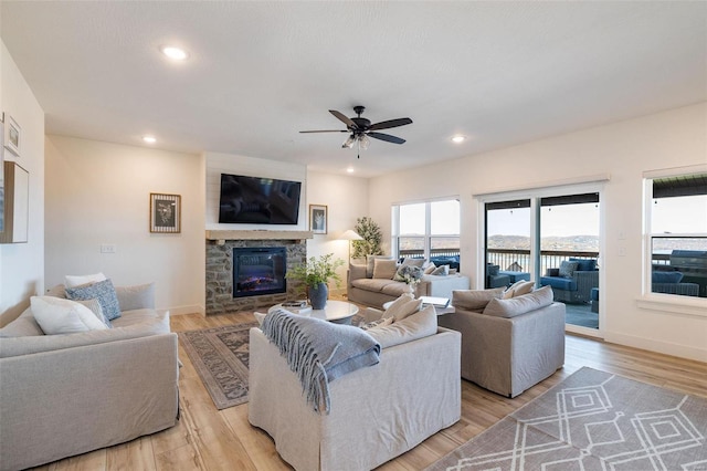 living room featuring light wood-type flooring, a fireplace, and recessed lighting