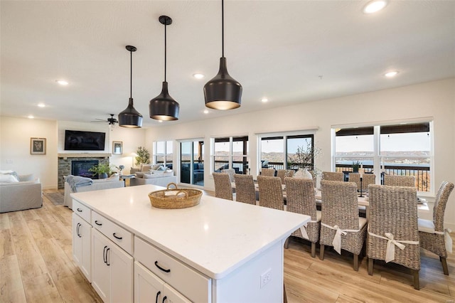 kitchen featuring a water view, white cabinetry, light countertops, and open floor plan