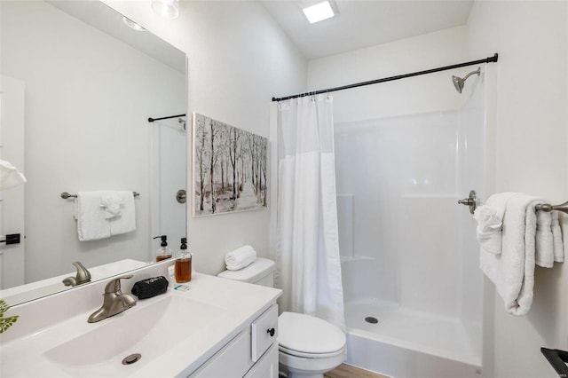 bathroom featuring a stall shower, vanity, and toilet