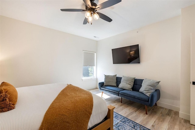 bedroom with light wood-type flooring, visible vents, baseboards, and a ceiling fan