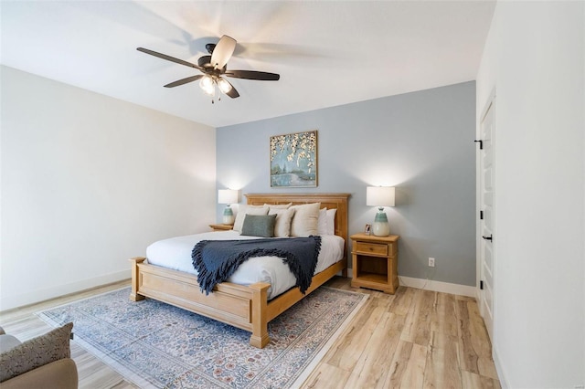 bedroom featuring light wood finished floors, baseboards, and a ceiling fan