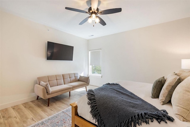 bedroom with ceiling fan, wood finished floors, and baseboards