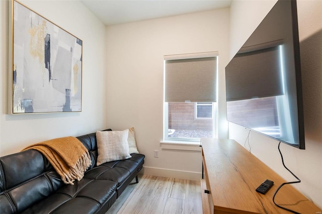 living area featuring light wood-style floors and baseboards