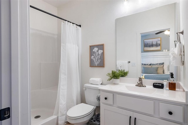 ensuite bathroom featuring connected bathroom, toilet, ceiling fan, curtained shower, and vanity