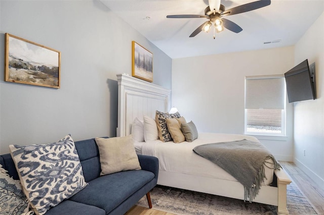 bedroom with baseboards, light wood-style flooring, visible vents, and a ceiling fan