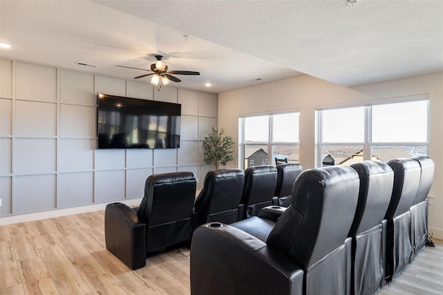 cinema room featuring ceiling fan, a textured ceiling, recessed lighting, visible vents, and light wood-type flooring